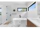 Bright bathroom featuring a soaking tub, walk-in shower, black hardware, and marble flooring at 13415 S Resort Dr, Conifer, CO 80433
