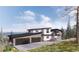Beautiful modern home with an attached garage and a serene landscape surrounding the property at 13415 S Resort Dr, Conifer, CO 80433