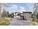 Stunning modern home boasts a sleek design with multi-car garage and beautiful landscaping at 13415 S Resort Dr, Conifer, CO 80433