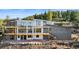Exterior showcasing spacious home with expansive deck, large windows offering natural light and hillside landscaping at 13415 S Resort Dr, Conifer, CO 80433