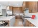 A gourmet kitchen featuring wood cabinetry, a large island with seating, and stainless steel appliances at 13415 S Resort Dr, Conifer, CO 80433