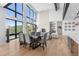 Open-concept living and dining area with floor-to-ceiling windows, stone fireplace and modern furnishings at 13415 S Resort Dr, Conifer, CO 80433