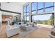 Bright, open-concept living room featuring floor-to-ceiling windows with mountain views and modern furnishings at 13415 S Resort Dr, Conifer, CO 80433
