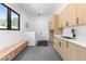 Spacious mud room features custom cabinets, sink, bench and a window with views of nature at 13415 S Resort Dr, Conifer, CO 80433