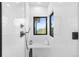 Modern shower with sleek fixtures, white tile, bench and a window view of the trees and mountains at 13415 S Resort Dr, Conifer, CO 80433