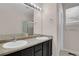 Bathroom featuring double sinks, large mirror, and separate shower area, offering modern convenience and comfort at 247 N Coolidge Way, Aurora, CO 80018