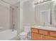 Well-lit bathroom with a shower-tub combination, neutral tile, single vanity, and bright mirror at 247 N Coolidge Way, Aurora, CO 80018