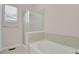 Bright bathroom with a soaking tub and shower, complemented by tiled walls and natural light from the window at 247 N Coolidge Way, Aurora, CO 80018