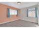 Bright bedroom featuring blue curtains, two windows, and a mix of painted accent and neutral walls at 247 N Coolidge Way, Aurora, CO 80018