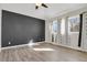 Large bedroom featuring dark accent wall, hardwood floors, and natural light at 247 N Coolidge Way, Aurora, CO 80018