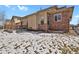 Back exterior featuring brick and wood siding, a patio, and a snowy backyard at 247 N Coolidge Way, Aurora, CO 80018