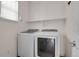 Well-equipped laundry room features a modern washer and dryer with a convenient shelf and natural light at 247 N Coolidge Way, Aurora, CO 80018