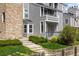 Exterior elevation of lakeside condo with stone facade, manicured lawn, and mature trees at 6861 Xavier Cir # 3, Westminster, CO 80030