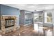 Open living room featuring hardwood floors, a stone fireplace, and access to the outdoor deck at 6861 Xavier Cir # 3, Westminster, CO 80030
