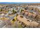 Aerial view of community and lake in the distance and brick building with balconies and roofs at 2263 E 129Th Ave, Thornton, CO 80241
