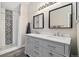 Stylish main bathroom features a double sink vanity, framed mirrors, and patterned tile in the walk-in shower at 2263 E 129Th Ave, Thornton, CO 80241