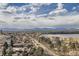 Expansive aerial view of a neighborhood with a lake, mountains and a playground under a bright, cloudy sky at 4200 W 17Th Ave # 1013, Denver, CO 80204