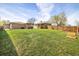 Expansive backyard with a lush green lawn, a wooden pergola and fire pit area for entertainment at 10500 Marion St, Northglenn, CO 80233