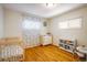 Bright bedroom with hardwood floors and a crib for infants at 10500 Marion St, Northglenn, CO 80233