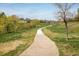 A serene community walking path winding through a grassy area with mature trees at 10500 Marion St, Northglenn, CO 80233