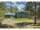 Backyard featuring a patio area, a well-maintained lawn, and a house with blue siding at 7701 Rollins Dr, Larkspur, CO 80118