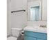 Modest bathroom showcasing blue vanity, tile floors, and a toilet with matching accessories at 7701 Rollins Dr, Larkspur, CO 80118