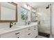Bathroom features dual sinks, a large mirror, and a glass walk-in shower at 7701 Rollins Dr, Larkspur, CO 80118