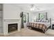 Cozy bedroom features a fireplace, ceiling fan, and window views to nature at 7701 Rollins Dr, Larkspur, CO 80118