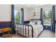 A bright bedroom with two large windows and blue curtains at 7701 Rollins Dr, Larkspur, CO 80118