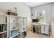 Bright, sunlit bedroom with a white desk and bookcase perfect for work and storage at 7701 Rollins Dr, Larkspur, CO 80118