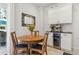 Cozy breakfast nook with wood table, bar with wine fridge, and white cabinets at 7701 Rollins Dr, Larkspur, CO 80118