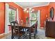 Bright dining room with an elegant chandelier, hardwood floors and red walls at 7701 Rollins Dr, Larkspur, CO 80118