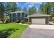 Charming two-story home with a well-manicured lawn and attached two car garage, nestled amongst mature trees at 7701 Rollins Dr, Larkspur, CO 80118