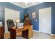 Comfortable home office with hardwood floors, wooden desk, and blue walls at 7701 Rollins Dr, Larkspur, CO 80118