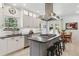 Open kitchen with a center island, modern lighting, tile floors, and stainless steel appliances at 7701 Rollins Dr, Larkspur, CO 80118