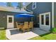 Outdoor patio with a table, six chairs, and a blue umbrella for shade at 7701 Rollins Dr, Larkspur, CO 80118