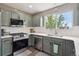 Modern kitchen with stainless steel appliances, white countertops, subway tile backsplash, and sage green cabinets at 4915 Parsons Way, Castle Rock, CO 80104