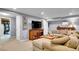 Finished basement featuring a sectional sofa, a coffee table, and a wall-mounted television at 3481 S Race St, Englewood, CO 80113