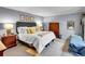 Bedroom featuring an upholstered bed, soft lighting, and a wooden dresser at 3481 S Race St, Englewood, CO 80113