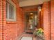 Covered front entry with brick facade, complemented by decorative potted plants at 3481 S Race St, Englewood, CO 80113