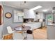Updated kitchen with white cabinetry, hardwood floors, skylight, and a breakfast nook with modern lighting at 3481 S Race St, Englewood, CO 80113