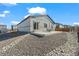 Backyard with gravel landscaping, concrete patio and a small garden at 1868 Homestead Dr, Fort Lupton, CO 80621