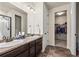 Bright bathroom features double sinks, dark wood cabinets, and a walk in closet at 1868 Homestead Dr, Fort Lupton, CO 80621