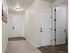 Inviting hallway with carpet, tile flooring, and white doors at 1868 Homestead Dr, Fort Lupton, CO 80621