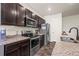 A kitchen with stainless steel appliances, granite countertops, and dark wood cabinets at 1868 Homestead Dr, Fort Lupton, CO 80621
