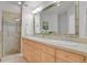 The full bath features double sinks with tile countertops, a large mirror, and a walk-in glass shower at 2500 E Cherry Creek South Dr # 116, Denver, CO 80209