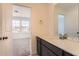 Bathroom featuring a modern vanity and mirror, complemented by natural light and a glimpse of the bedroom at 647 Nightsky St, Erie, CO 80516