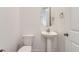 Bright half bathroom with a pedestal sink and white fixtures at 647 Nightsky St, Erie, CO 80516
