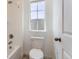 Cozy bathroom featuring tiled walls, a bathtub, and a toilet, bathed in natural light from the window at 647 Nightsky St, Erie, CO 80516