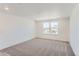 Bright bedroom with neutral carpet, white walls, and a pair of windows offering pleasant neighborhood views at 647 Nightsky St, Erie, CO 80516